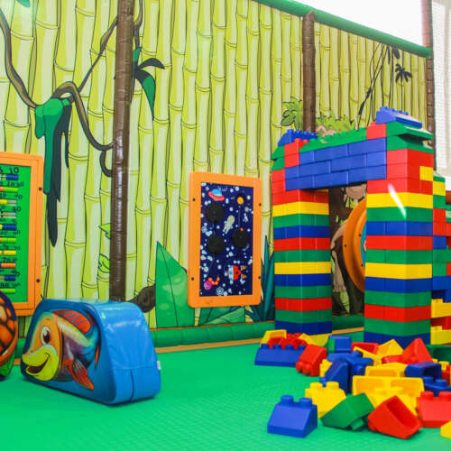 Kinderhoek in de indoor speeltuin met bouwblokken, soft play en wandspelen
